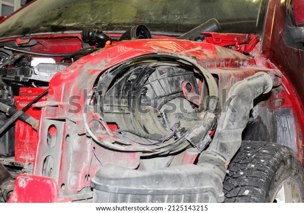 A series of car body repair. Close-up of a\
disassembled red car awaiting repair and repainting. Disassembled\
car in the service. Body\
repair.