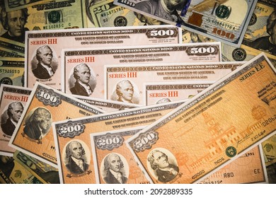 Series HH and Series EE United States Treasury Savings Bonds surrounded by US currency.  Issued by the US Government and  purchased from the U.S. Department of the Treasury. - Shutterstock ID 2092889335