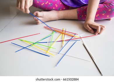 Series Of Kid Playing Pick Up Sticks Fun Game On Floor