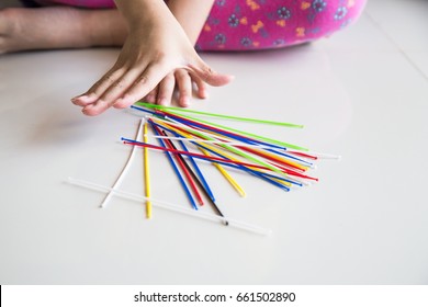 Series Of Kid Playing Pick Up Sticks Fun Game On Floor