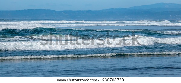 A series of multiple turbulent waves roll on
shore at Moss Landing State Beach, along the Monterey Bay of the
central coast of California. 