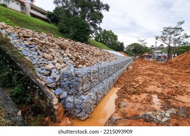 Series of slope retention construction design with rocks and mesh to manage landslide in residential area