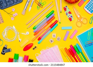 Series Of Stationery Items For Kids, Colored Pens, Labels, Paper Clips, Masks On Yellow Background, Back To School Concept, Flat Lay