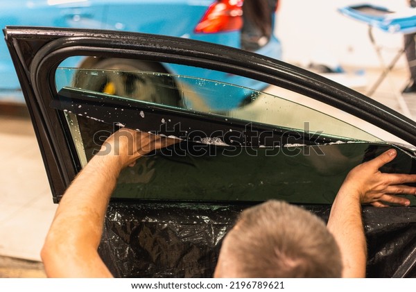 A series of tinting car windows.\
Installation of tinting film on the car glass. Specialist in the\
installation of tinting film in the process of\
work.