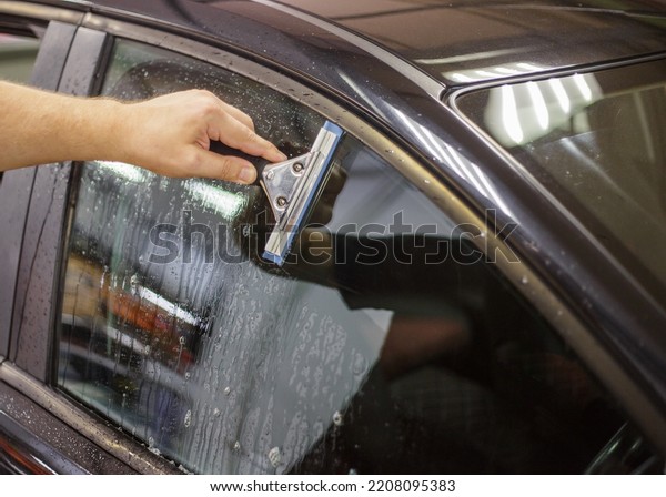 A series of tinting car windows.\
Installation of tinting film on the car glass. Specialist in the\
installation of tinting film in the process of\
work.
