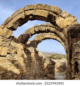 A series of weathered stone arches from an ancient structure, reflecting timeless architectural beauty - Powered by Shutterstock