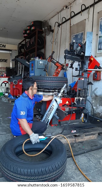 Series of worker\
removing tire from rim with removal machenery equipment. Banyuwangi\
- Indonesia, July 01,\
2019