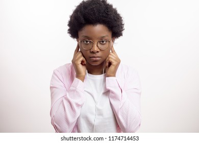 serios afro woman putting on earphones to listen to an audio book. close up portrait, isolated white background, education, concentration - Shutterstock ID 1174714453