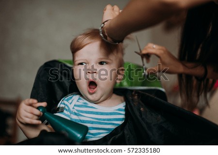 Similar – Beautiful boy getting a haircut with scissors