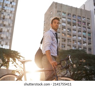 Serious about his carbon footprint as low as possible. Shot of a businessman commuting to work with his bicycle. - Powered by Shutterstock