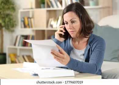 Serious Adult Woman Checking Letter Calling On Smart Phone Sitting In The Livingroom At Home