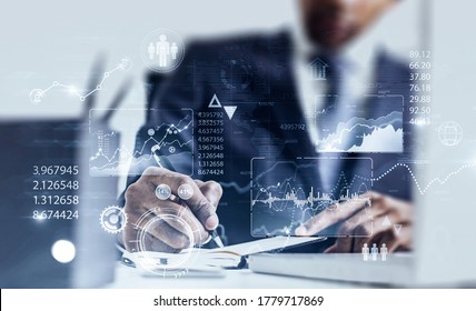 Serious African American businessman working in blurry office with double exposure of HUD infographic interface. Concept of statistics and data analysis. Toned image - Powered by Shutterstock