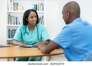 Serious African American Female Doctor Talking With Patient About Healthy Lifestyle At Hospital