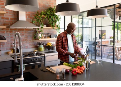 Serious African American Senior Man Cooking In Kitchen. Retirement Lifestyle, Leisure And Spending Time At Home.