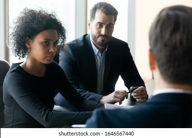 Serious african businesswoman with colleague listening leader coaching at briefing. Diverse team discuss business project with mentor in boardroom at company meeting. New candidate at job interview - Shutterstock ID 1646567440