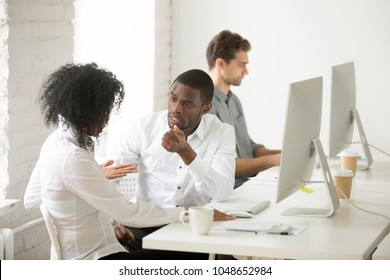 Serious African Colleagues Discussing Project Together At Workplace, Black Coworkers Talking Solving Problem In Multiracial Office, Afro American Teammates Having Disagreement Or Conflict At Work