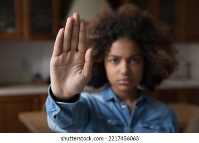 Serious African teenager girl looking at camera raises her palm showing stop gesture, against emotional and physical abuse, bullying at school, racial inequality, struggling for women rights, close up - Shutterstock ID 2217456063