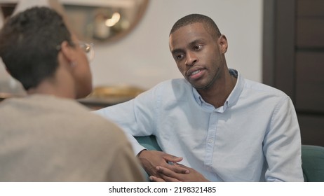 Serious African Woman Talking To African Man On Sofa