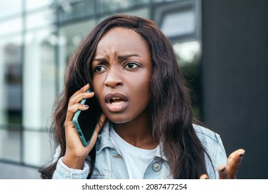 Serious Angry Beautiful African American Pretty Woman Hold Hand Phone Talking Chatting Friends Colleague Standing Street Outside Conversation Speaking Shouting Blur Bokeh Background
