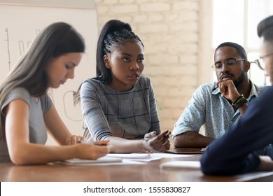 Serious Anxious Colleagues Gathered Together In Boardroom Solve Work Issues, Multi Racial Businesspeople African Caucasian Mates During Briefing Meeting In Office, Teamwork Problems Discussion Concept