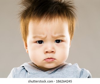 Serious asia baby boy eyebrow frown