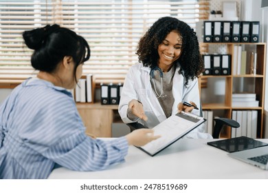 Serious Asia female doctor using clipboard is delivering great news talk discuss results or symptoms with female patient in clinic or hospital o - Powered by Shutterstock