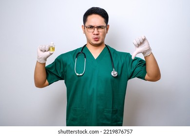 Serious Asian Doctor Holding Urine Pot While Showing Thumb Down, Showing Bad Result Test Standing Over White Background