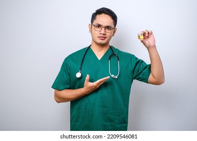 Serious Asian Male Nurse Or Doctor Showing And Pointing At Urine Pot Sample Standing Over Isolated White Background