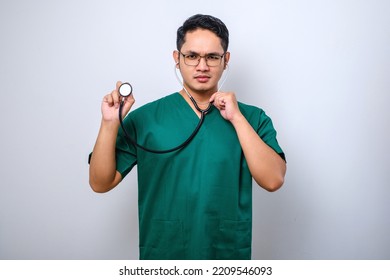 Serious Asian Male Nurse Or Doctor Examine Patient Lungs, Using Stethoscope, Listening Closer, Standing White Background