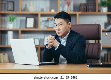 Serious Asian Sitting At Desk In Office Looking At Camera , Portrait Of Businessman Boss