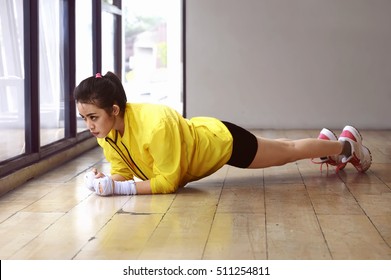 Serious Asian Woman Doing Plank Workout Over Wooden Floor