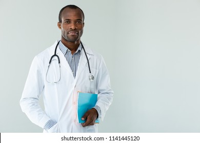 Serious Attitude. Concentrated Professional Doctor Holding Patients Notes Against White Background