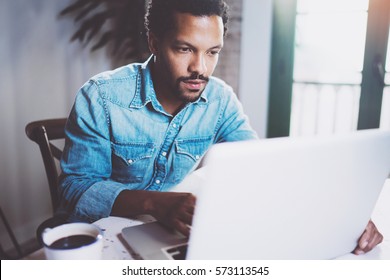 Serious Bearded African Man Working On Laptop While Spending Time At Home.Concept Of Young Business People Using Mobile Devices.Blurred Background, Crop.