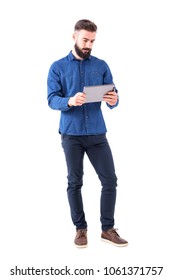 Serious Bearded Business Man Holding And Watching Tablet In Both Hands. Full Body Isolated On White Background.