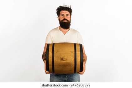 Serious bearded man with barrel or keg of whiskey or wine. Winemaking. Handsome man with oak barrel or cask of beer for pub or bar. Brewer carrying wooden barrel with craft beer. Brewery concept - Powered by Shutterstock