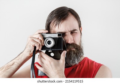Serious bearded man with camera. Photographer self portrait with vintage photo camera.