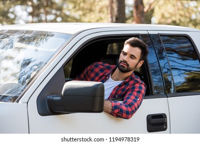 Serious Bearded Man Driving Pickup Truck In Forest