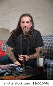 Serious Biker Gang Member With Liquor And Dagger On Table