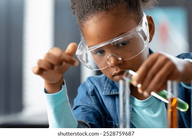 Serious biracial schoolgirl in safety glasses doing experiment in science class with copy space. Education, inclusivity, childhood, elementary school and learning concept. - Powered by Shutterstock