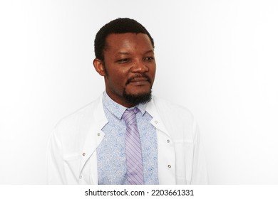 Serious Black Doctor Man With Small Beard In White Coat Bright Shirt Isolated On White Background. Attractive Adult Black Physician Therapist Portrait, Attractive Practitioner Family Doctor