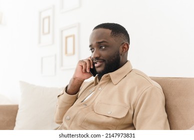 Serious Black Freelancer Talking On The Phone While Working From Home. Young African American Businessman Talking To Customers On Mobile Phone