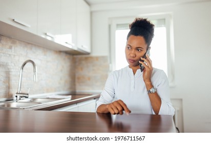 Serious Black Woman Talking To Someone Over The Mobile Phone.