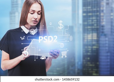 Serious blonde woman in black dress using tablet computer in blurred city with double exposure of online shopping interface and PSD2 text. Concept of online payment and ecommerce. Toned image - Shutterstock ID 1458659132