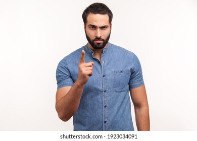 Serious Bossy Man With Beard In Blue Shirt Warning With Finger, Scolding, Strictly Looking At Camera. Indoor Studio Shot Isolated On White Background