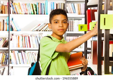 Serious Boy Looks And Searches Book On Shelf