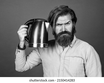 Serious Brutal Man With Moustache And Beard. Electric Home Device. Bearded Man Use Red Electric Kettle. Male Housekeeping Concept. Need Some Hot Water. Man Going To Drink Tea Or Coffee