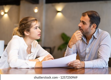 Serious Business Professional Discussing Report. Two Colleagues Studying Papers And Talking In Meeting Room. Business Meeting Concept