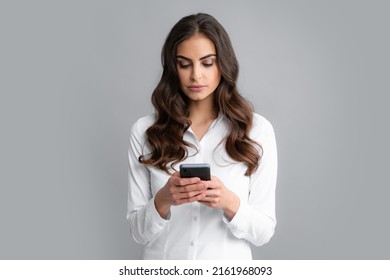 Serious Business Woman Looking At The Phone Screen, Reading Message On Smartphone, Typing Text On Smart Mobile Phone. Female Freelancer Chatting By Mobile Phone.