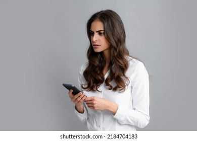 Serious Business Woman Looking At The Phone Screen, Reading Message On Smartphone, Typing Text On Smart Mobile Phone. Female Freelancer Chatting By Mobile Phone.