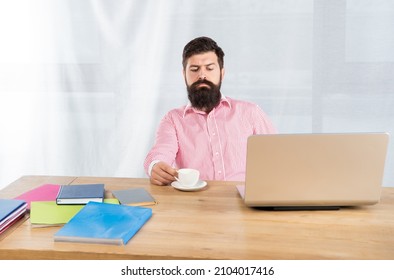 Serious Businessman At Office Desk. Office Work. Tea Break